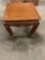 Vintage wooden table with intricate designs in the wood and claw feet.