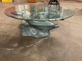 Glass table with dolphins as base and glass top.