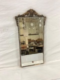 Vintage hanging mirror with an ornate frame.