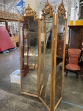 Three panel room divider with mirror and gold trim.