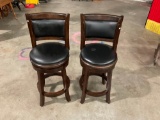 Set of two bar stools with padded seats and backrest.