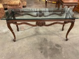 Glass top entryway table with wooden base.