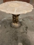 Marble top table with cherubs as the base holding up.