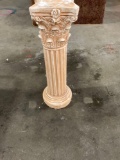 Garden pedestal with floral designs around the top.