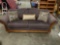 Nice Large Eggplant upholstered loveseat with rolled arms and 3 pillows.