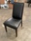 Black upholstered chair with tubed backrest trim and wood frame
