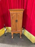 Wooden Jewelry cabinet with doors and 3d trim on front.