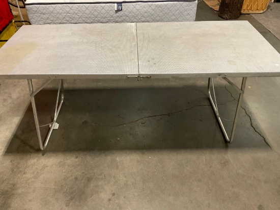 Aluminum folding table with handles.