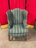 Vintage wooden green-upholstered wing back armchair