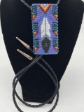 Vintage Native American rectangular beaded Bolo tie necklace - feather on lavender background