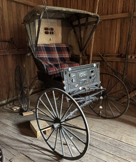 Antique horse drawn buggy, large wooden spoke wheels, fold down top, plaid upholstered seat