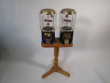 Lot of two gumball/candy machines on wooden display stand.