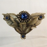 Antique metal brooch with blue glass stones