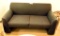 Lot #1252 - Mueller Furniture Corporation black upholstered loveseat (30” x 57” x 31”) and