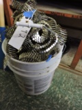 5 gallon pail overflowing with coiled air gun nails