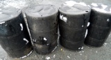 Four Black Hard Plastic Trash Barrels