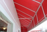 Approximate 48” x 27’ outdoor aluminum framed awning with red canvas