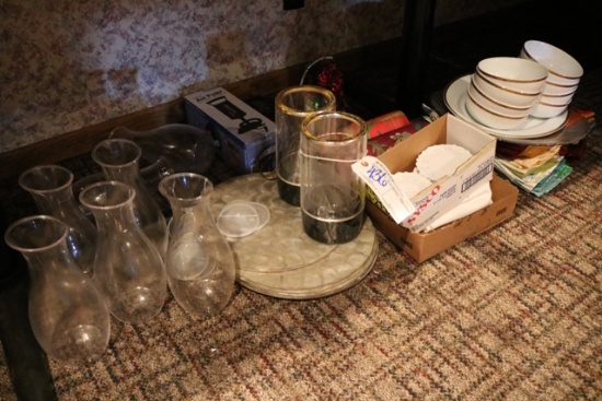 Assorted plates, table covers, water pitchers under table