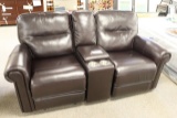 Dark brown leather rocking sofa with center arm rest