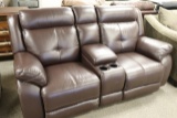 Brown leather rocking sofa with center arm rest