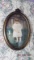 Oval painting of child in floral carved frame