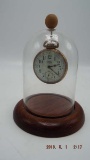 Gold tone pocket watch in glass dome display