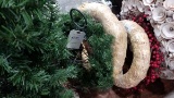 Assorted wreaths, small holiday tree, and decorator stand