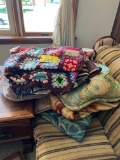Stack of throw pillows, blankets, & quilts