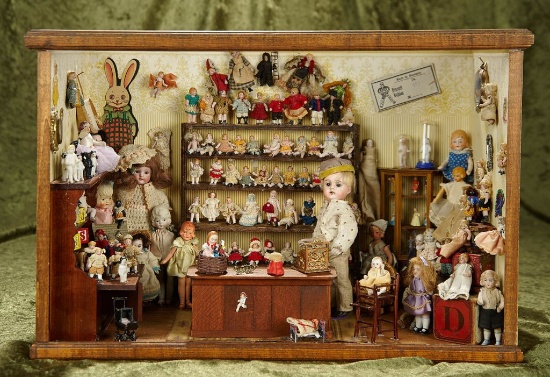 19"w. Wooden framed "The Doll Shoppe" filled with miniature bisque antique dolls. $1200/1600
