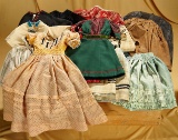 Lot of various costumes for early dolls in wooden packing box, mid-1800s. $400/600