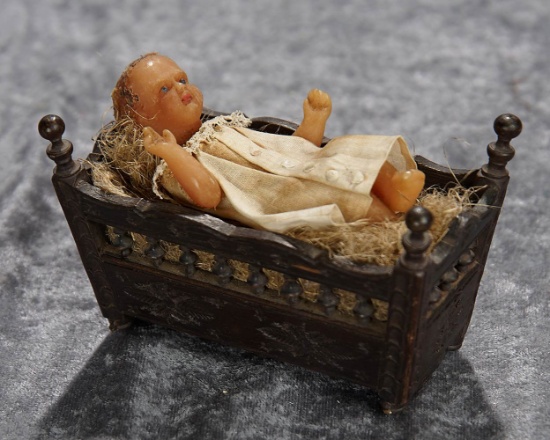 3 1/2" Early wax baby presented in carved wooden cradle. $400/500