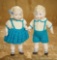 Pair, German all-bisque boy and girl with sculpted curly hair, blue hair bow, by Hertwig. $200/300