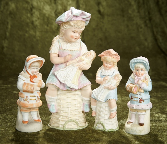 6 1/2"-10" Four German all-bisque figures of bonnet head children holding dolls. $500/800