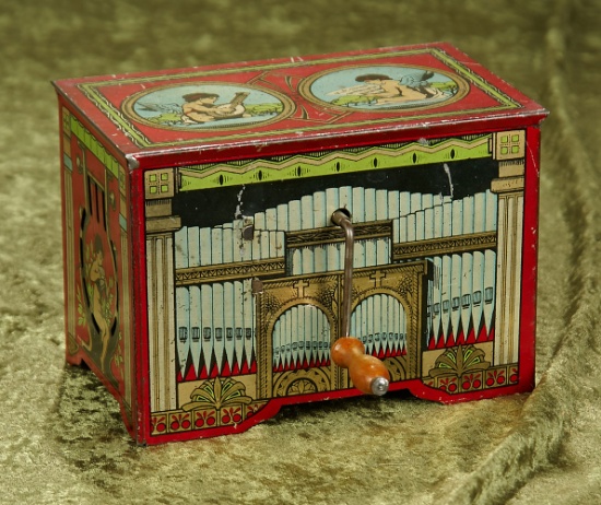 5" German tin litho hand-crank pump organ toy with cherub graphics in working condition.