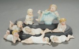 Eight German All-Bisque Miniature Babies in Sculpted Smocks 300/400