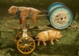 Two early bell toys including pig pulling a two-wheeled cart with bell.