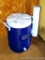 Rubbermaid 5 gallon drink tote with spigot and detachable cup dispenser. In good condition.