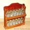 Vintage spice rack with jars by Crystal Food Products. Each jar has a copper toned lid. Measures