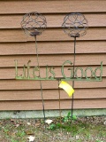 Decorative yard stakes include two wire balls and a 'Life is Good' stake, which is 24