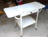 Vintage typewriter stand is in good condition and has two fold up extensions. Measures 26-1/2