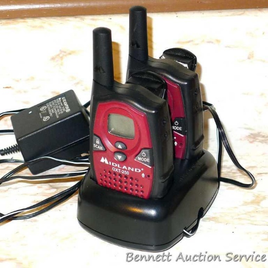 Pair of Midland GXT-250 two-way radios with charging station and pocket clips. Both units turn on.