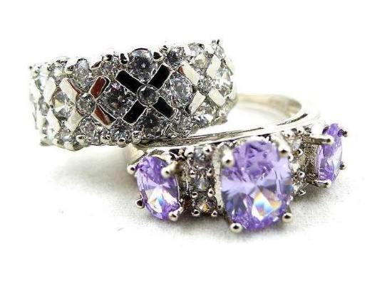 Two rings. Seller's description states 'white sapphire band/ring, size 9; purple amethyst ring, size