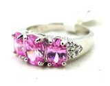 Seller's description states 'pink sapphire, three stone band ring, size 8'.
