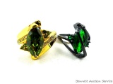 Two rings. Seller's description states 'marquise cut peridot, size 8; green emerald 'S' ring, size