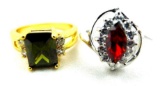 Two rings. Seller's description states 'marquise cut red ruby crystal ring, size 7; olive green
