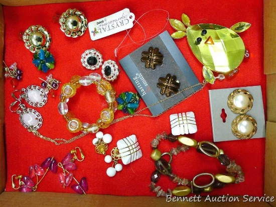 Assorted sparkly jewelry incl. clip and pierce earrings, rhinestone necklace, and bracelets.