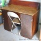 Wooden desk and metal chair appear in good condition with a chip on one corner of the desk. Desk is