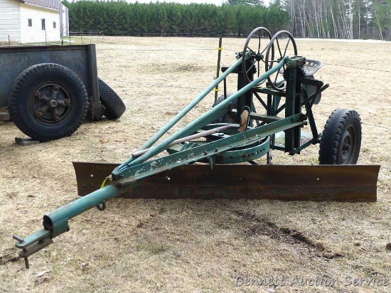 Pull behind road grader with 9' blade that swivels and tilts. Height and bevel adjustment works.