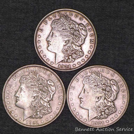 Three Morgan silver dollars including 1921, 1921-S, 1921-D.