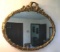 Oval Mirror: Decorative wood-frame gold-colored oval mirror. 38